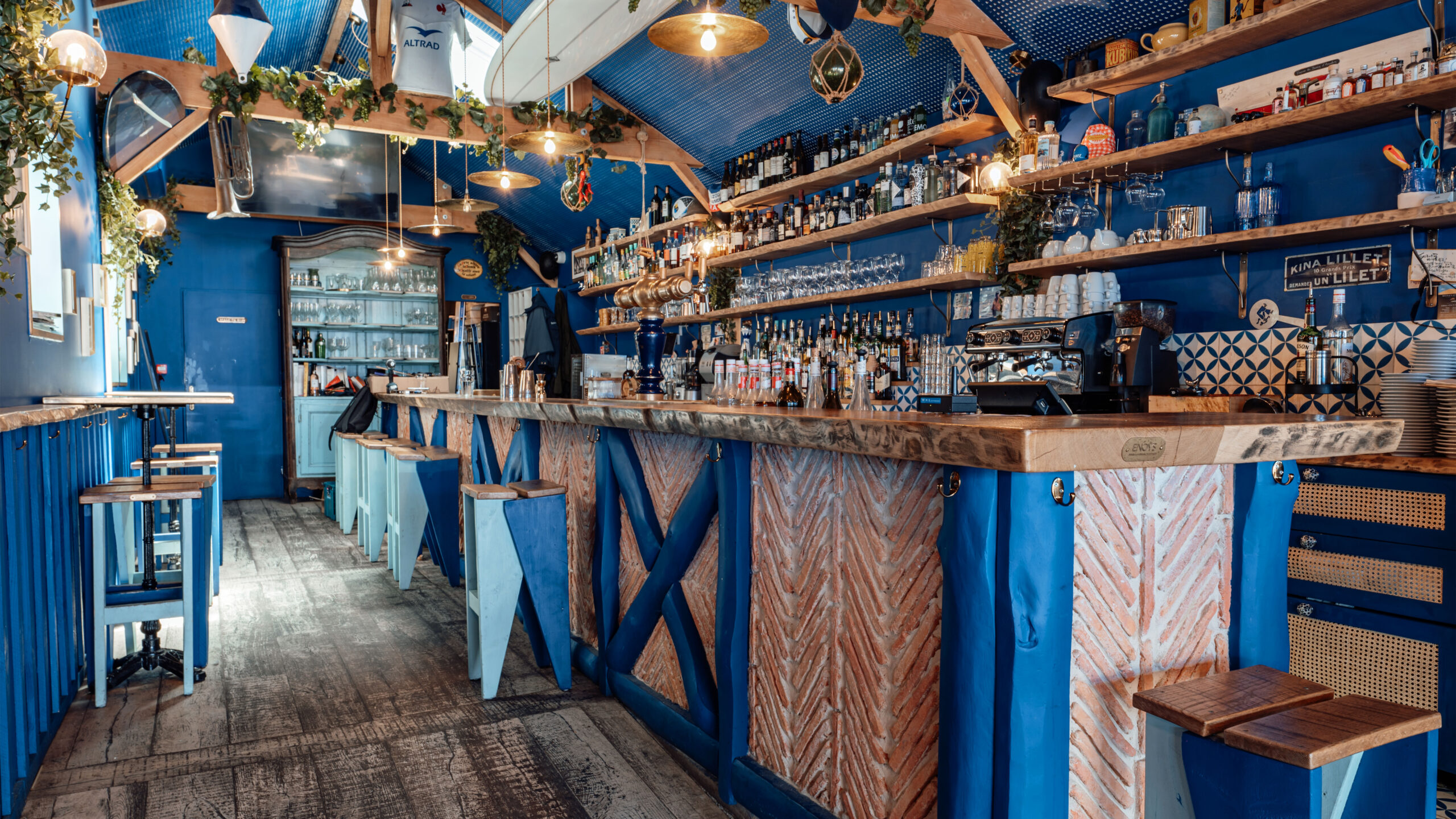 Photo intérieure restaurant Fernande au Moulleau. Bar avec des tabourets OCKH en bleu et bois naturel.